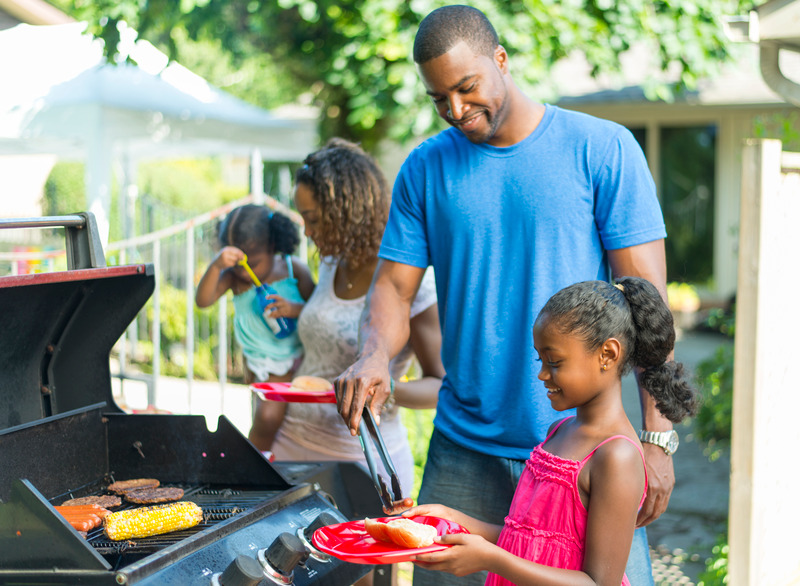 Family having a barbeque in the summertime.